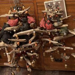 Photo of wind chimes made of wood, featuring cardinals and black bears.